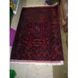 An Eastern rug, red ground with geometric patterns and borders, some wear, 61" x 40".