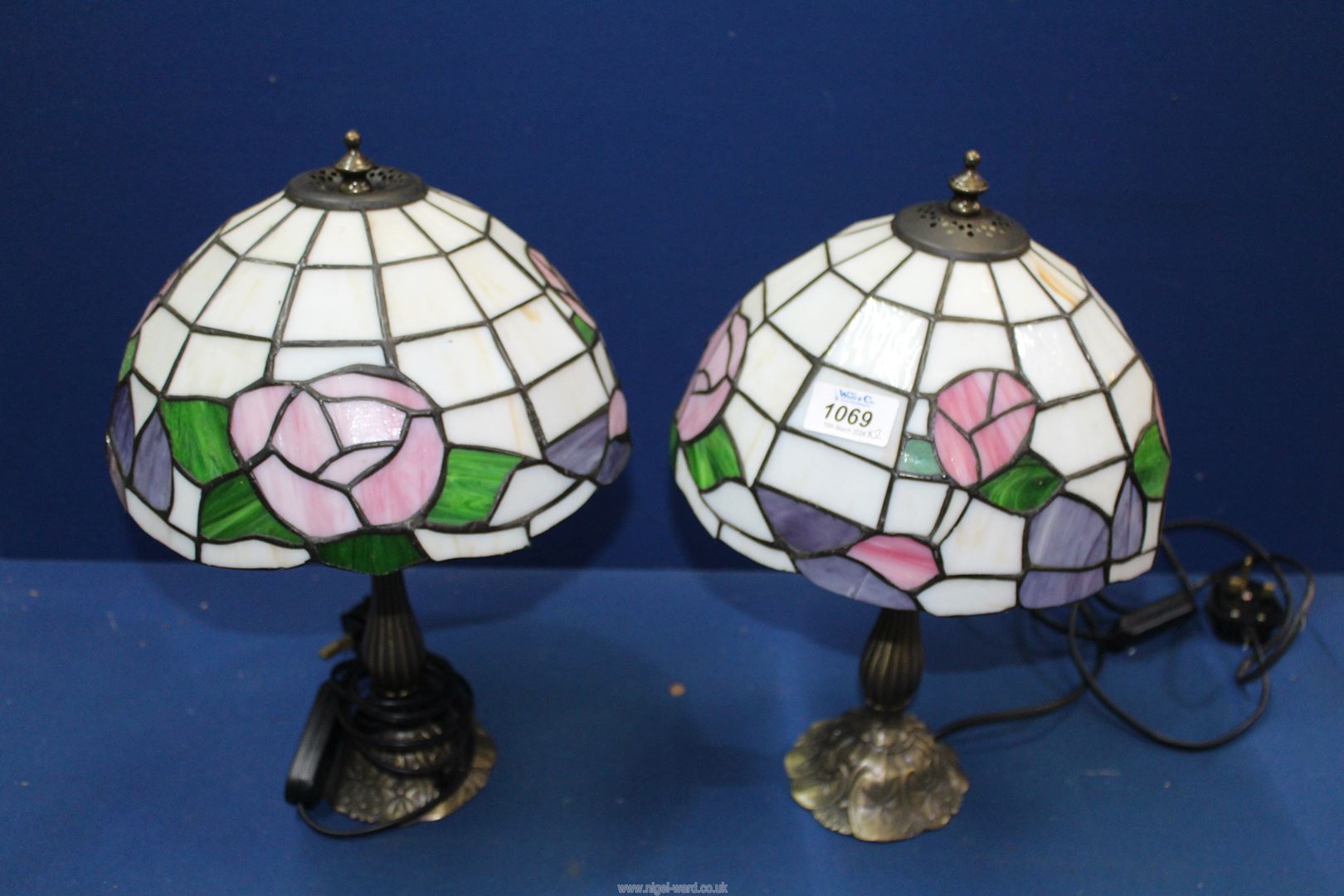 A pair of Tiffany style table lamps with stylised floral detail to the shades, each 15" tall,