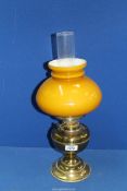 A brass Oil lamp with amber glass shade and chimney, 18" tall.