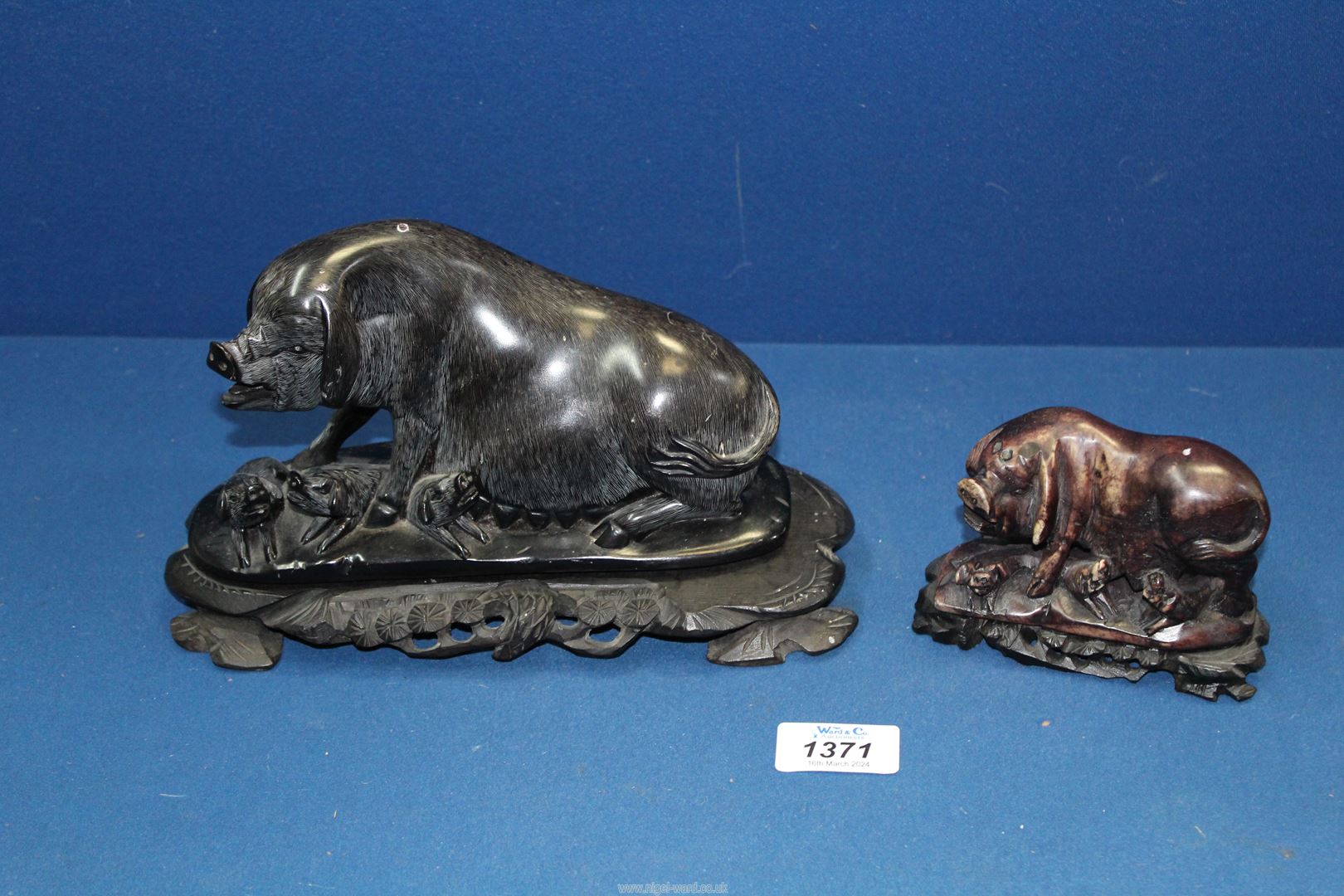 A nicely moulded black Soapstone chinioserie carved Pig with a litter of piglets on a carved
