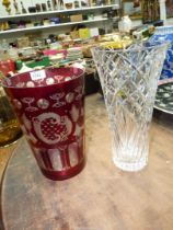 A large red and etched glass vase with church, bird and stag decoration and a tall cut glass vase,