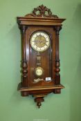 A mixed woods cased Wall Clock having a two train spring driven movement to the face with Roman