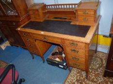 An attractive probably Edwardian light Oak Kneehole Desk with a central frieze drawer flanked to