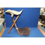 A Campaign folding tripod stool, 19th century, with both leather and canvas seating slings.