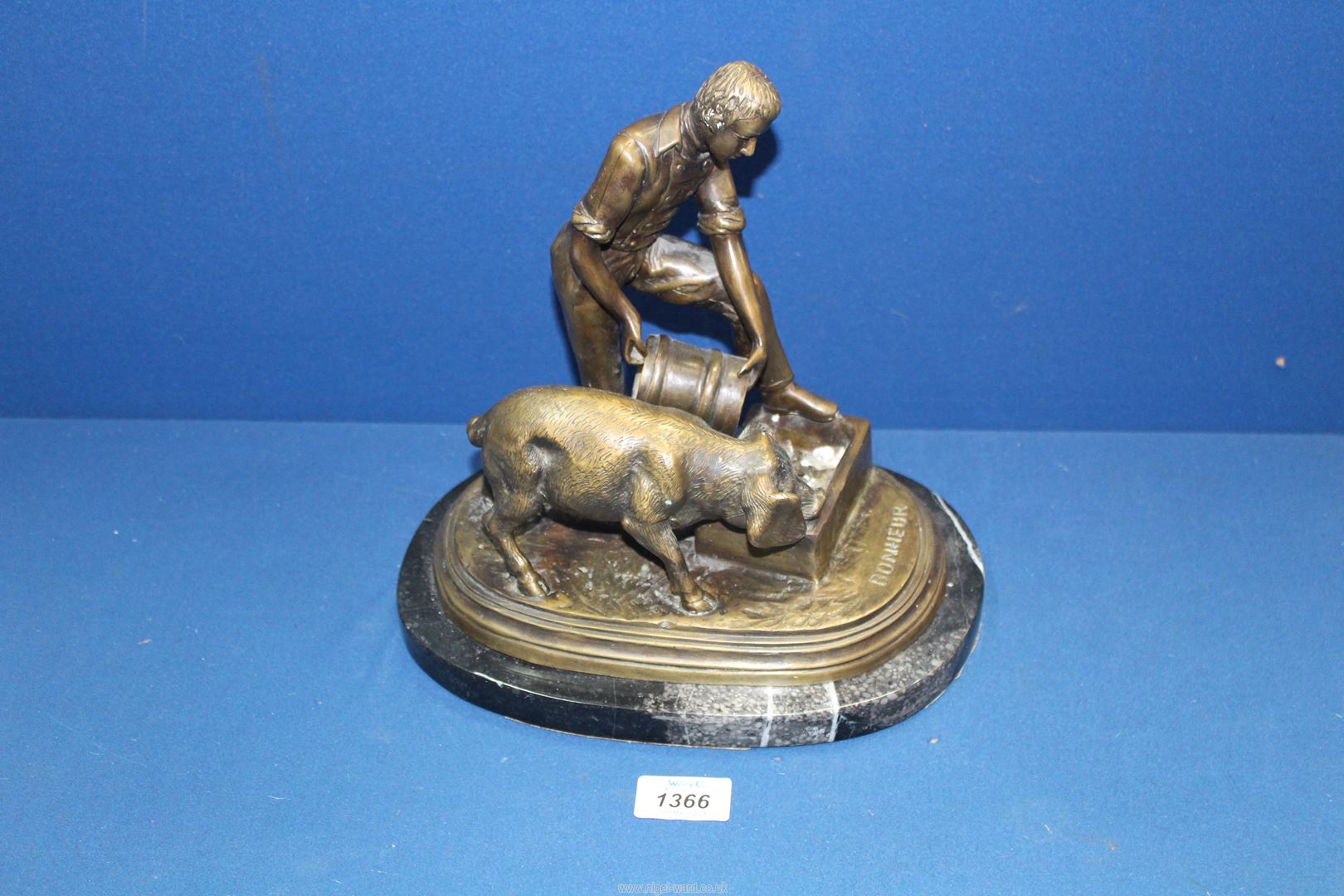 A heavy Bronze on marble plinth of a Farmer feeding a pig,