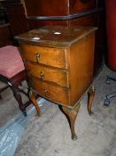 A bow fronted Walnut finished Bedside Table having three drawers with tear-drop handles and