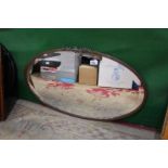 An Arts & Crafts style oval copper framed wall mirror, 29 1/2" x 17".