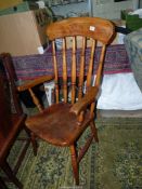 A solid Elm seated Kitchen open armed Armchair having turned legs,
