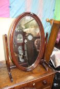 A Mahogany framed oval swing Mirror, 18 1/2'' wide x 27 1/2'' high.