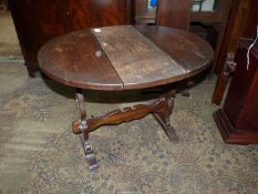An Oak swivel-top drop leaf Occasional Table having fret-worked legs and peg-joyned stretcher,