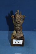 An ornate Javanese bronze finial from a temple bell, cast as a grotesque demonic guardian,