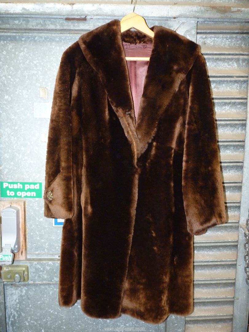 A dark brown fur coat with large buttoned cuffs and deep shawl collar.