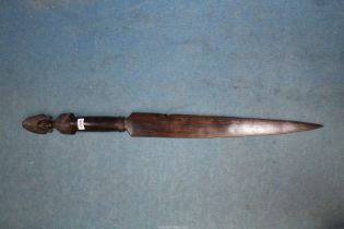 A tribal carved ebony sword club, the pommel shaped as a head with elaborate crest, 38" long.