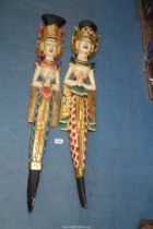 A pair of carved and painted, wall hanging figures of Thai/Balinese women, 32" tall.