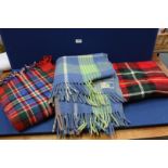 Three blankets, two red tartan travel rugs and a blue and green wool blanket.
