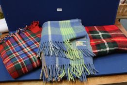 Three blankets, two red tartan travel rugs and a blue and green wool blanket.
