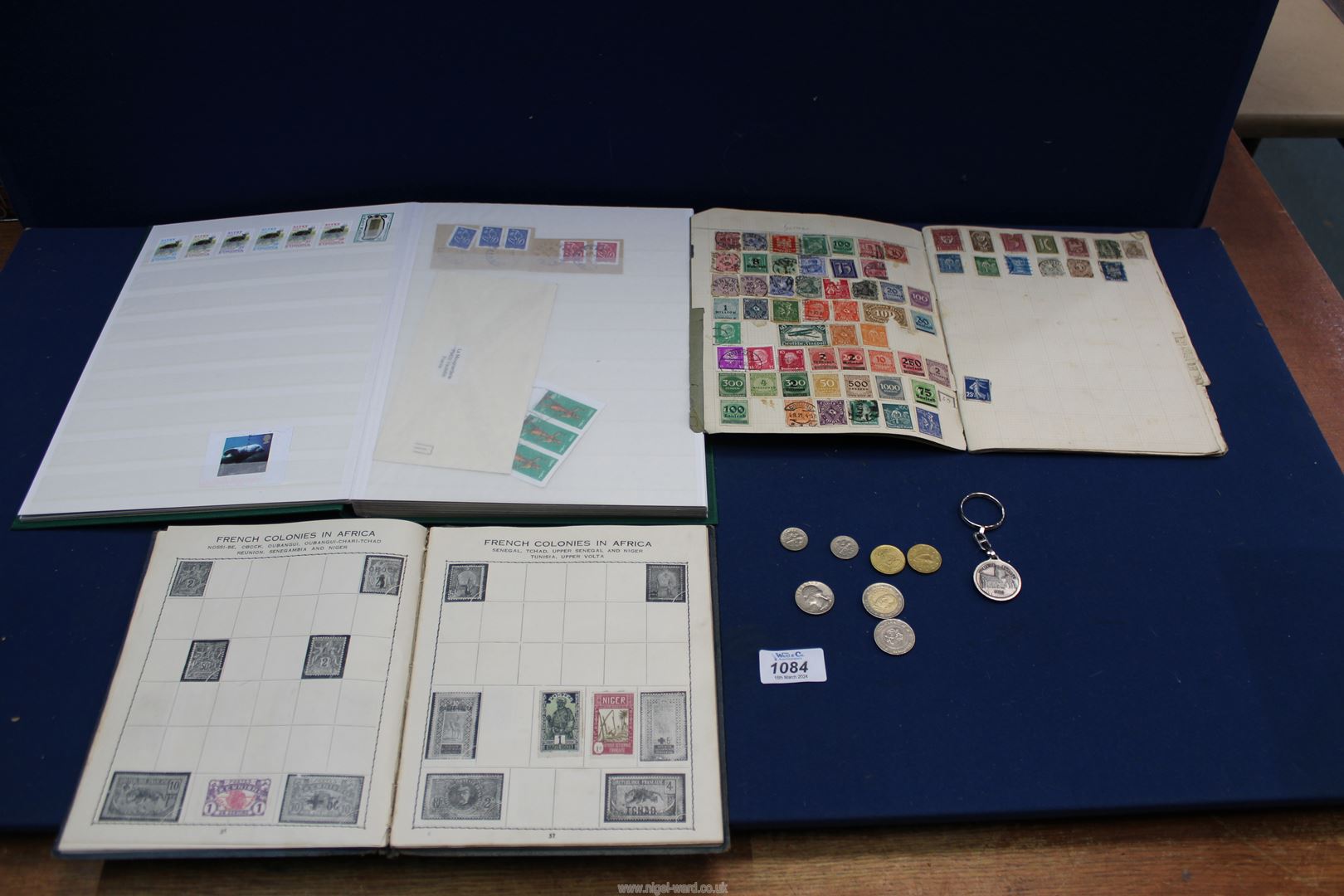 Three stamp albums with a quantity of stamps inside (one album nearly empty) and a small quantity