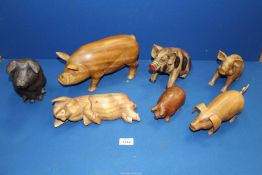 A quantity of wooden pigs including sleepy pig, spotty pig, etc.