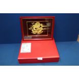 A gold plated Chinese Dragon picture in red box with gold certificate.