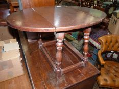 An Oak dropleaf occasional Table standing on sloping turned legs,