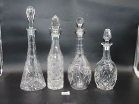 Four tall decanters all having stoppers.