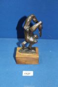 A bronze figure of an acrobat standing on their hands on a wooden plinth, 7 1/2" including plinth,