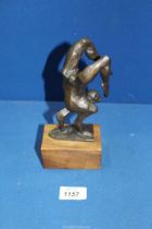 A bronze figure of an acrobat standing on their hands on a wooden plinth, 7 1/2" including plinth,