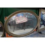 An oval gold painted mirror with beaded decoration, 33" x 23 1/2".