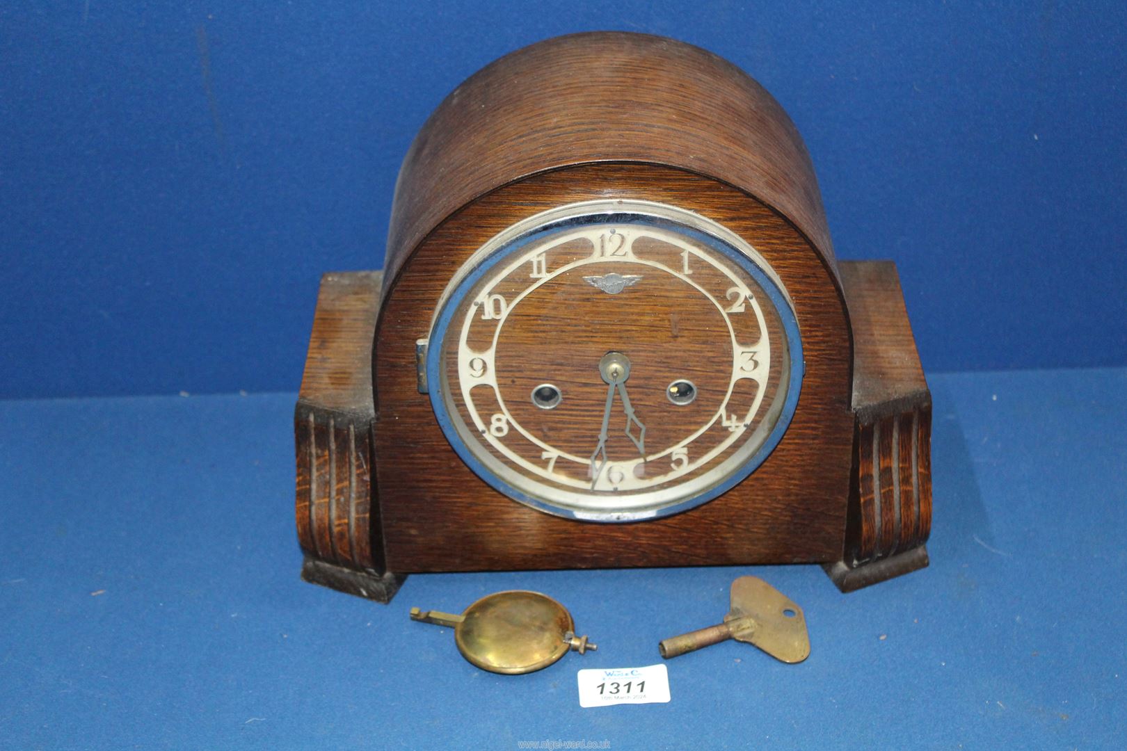 A Bentima Mantle clock with Arabic numerals, with key and pendulum, 11 1/2" wide x 9" high.