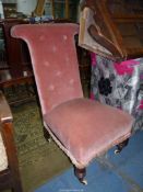 A circa 1900 high back Chair upholstered in dusky pink velvet type fabric and standing on turned