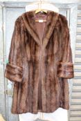 A ladies brown Mink coat with deep cuffs and side pockets.