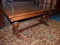 An Oak rectangular Coffee Table standing on heavy turned supports to either end united by a central