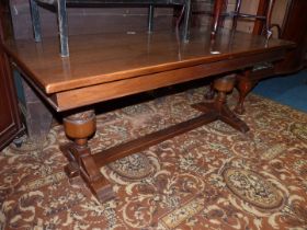 An Oak rectangular Coffee Table standing on heavy turned supports to either end united by a central