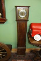 An Oak cased Grandmother Clock having a brass and silver face with Roman numerals,