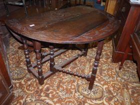 A surprisingly heavy Oak drop-leaf gate-leg Table having geometric carved/poker worked detail to