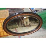 A large oval bevel edged Edwardian mirror, 82cm x 55cm approx.