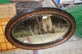 A large oval bevel edged Edwardian mirror, 82cm x 55cm approx.