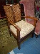 A mixed woods open armed Elbow Chair having a caned back,