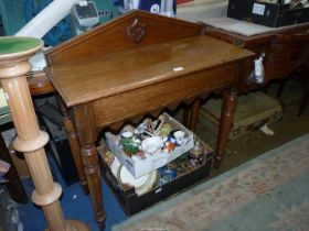 An Oak Side Table having a pediment incorporating a fretworked shield motif and standing on turned