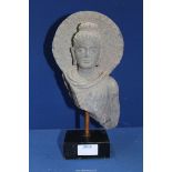 A fine Gandhara stone bust of Buddha within an aureole, c.