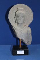 A fine Gandhara stone bust of Buddha within an aureole, c.