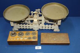 A cast metal 3kg weighing Scales with an incomplete wooden box of brass weights.