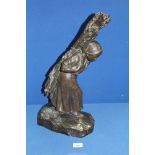 A heavy cast Bronze figure of a female peasant carrying firewood on her back, signed T.