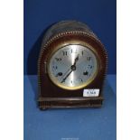 A wooden cased domed Mantle clock, with key and pendulum, 6 1/2" wide x 8" tall.