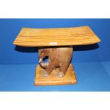 A curved top Stool with carved elephant base, 18" long x 10 1/2" wide x 12 1/2" high.