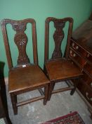 A pair of Oak country Side Chairs having solid seats and carved details to the front including to