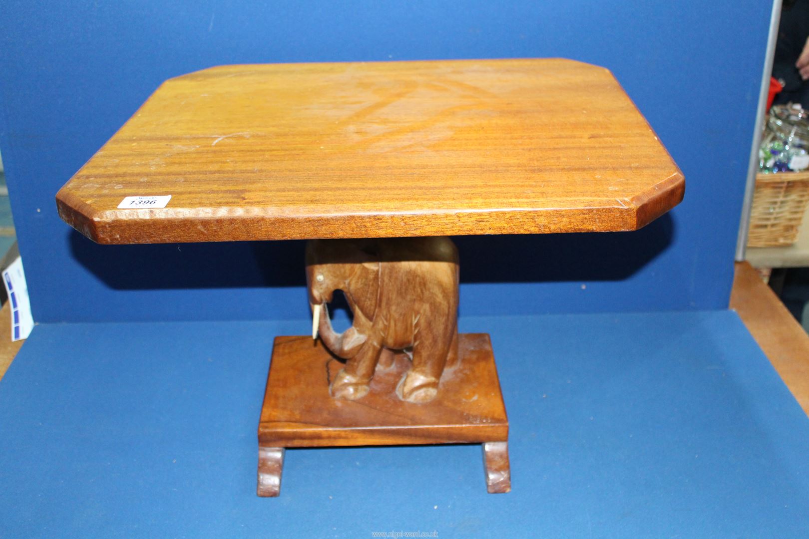 An Occasional table with carved elephant base, 21" long x 16 1/2" wide x 15" high.