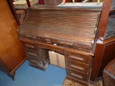 A dark Oak roll top Desk having an interior with two drawers, double pedestal and eleven recesses,