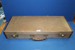 A Gun case in brown canvas with leather bindings and brass fittings, with key, 28 1/4'' long.