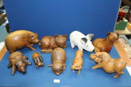A large quantity of wooden Pig ornaments including one white painted.